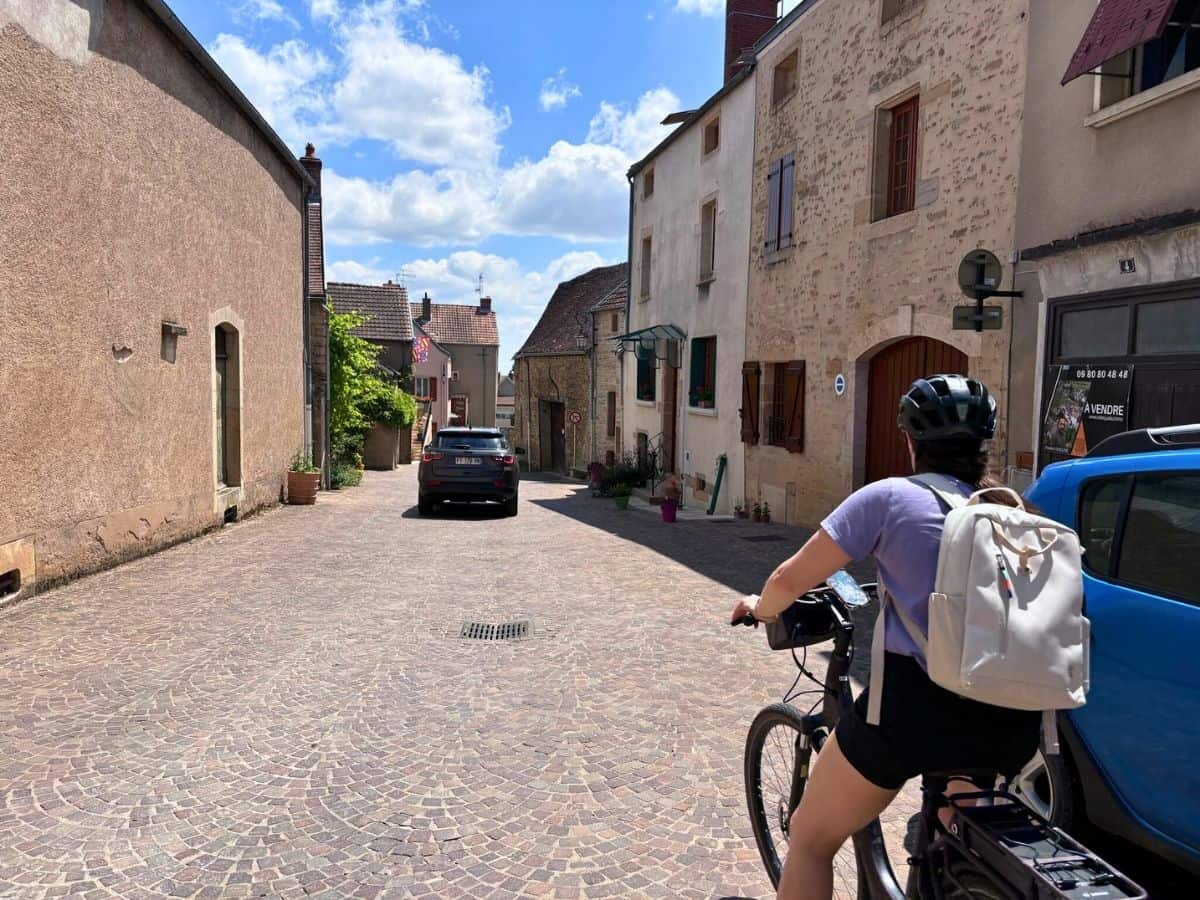 Liz riding an electric bike in Burgundy, France. Bicycling is one of our favorite soft adventure travel activities.