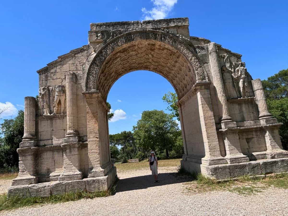 Liz standing under the Triumphal Arch at the entrance to Glanum