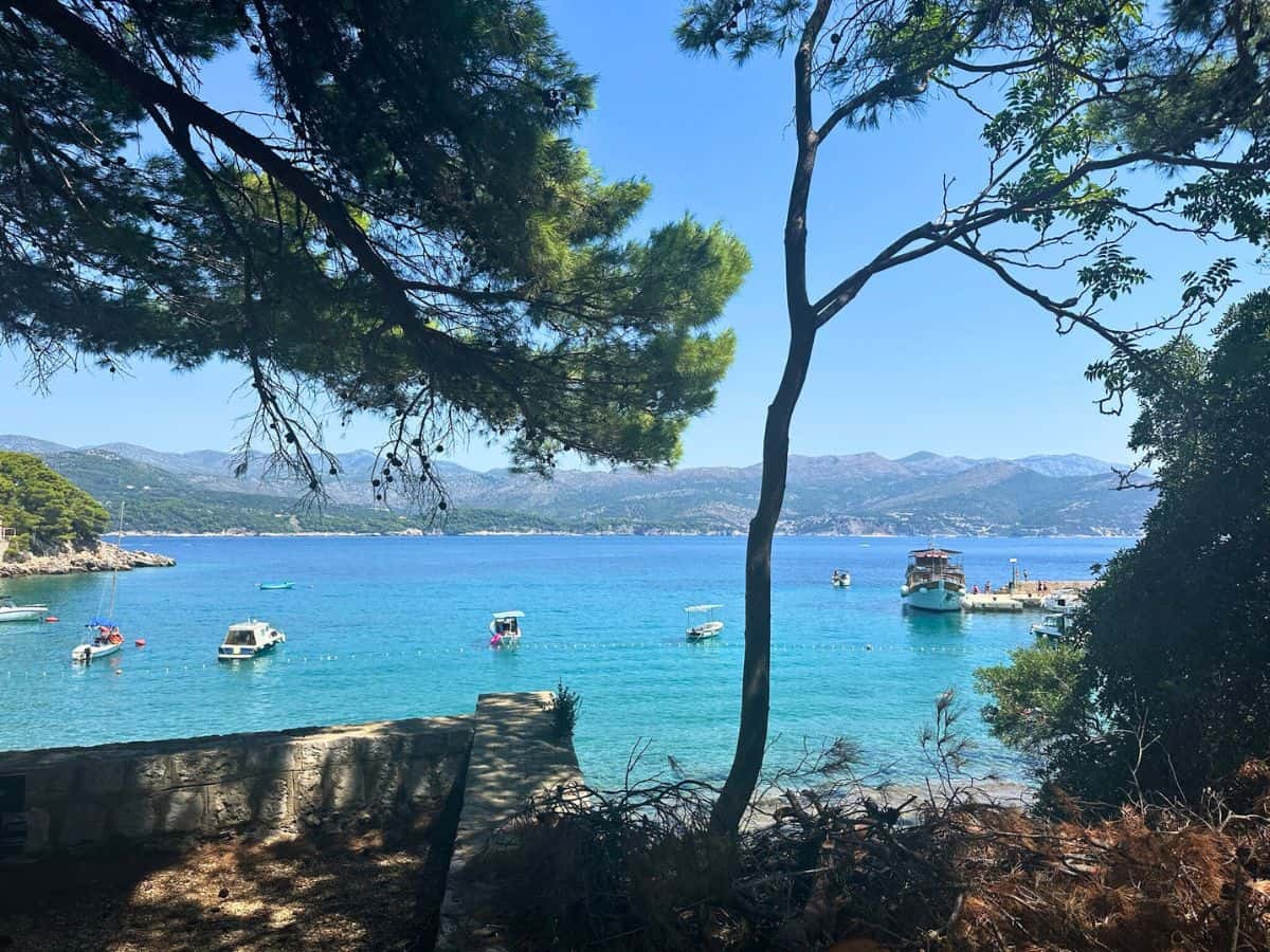 Turquoise water and small boats in a bay along Kolocep Island