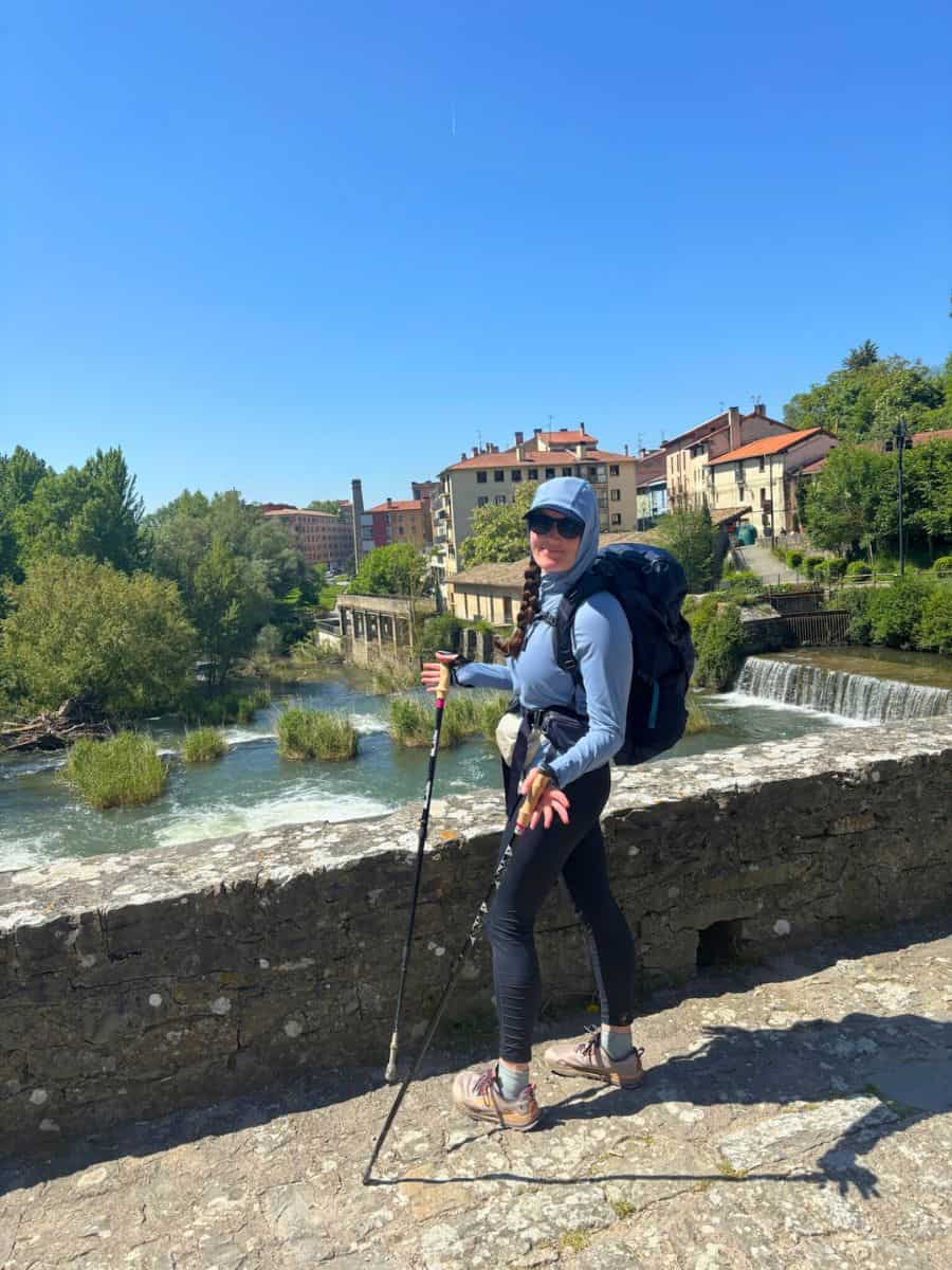 Liz happily posing for a photo in her long sleeve hooded UPF shirt - one of our best Camino packing tips is UPF clothing.
