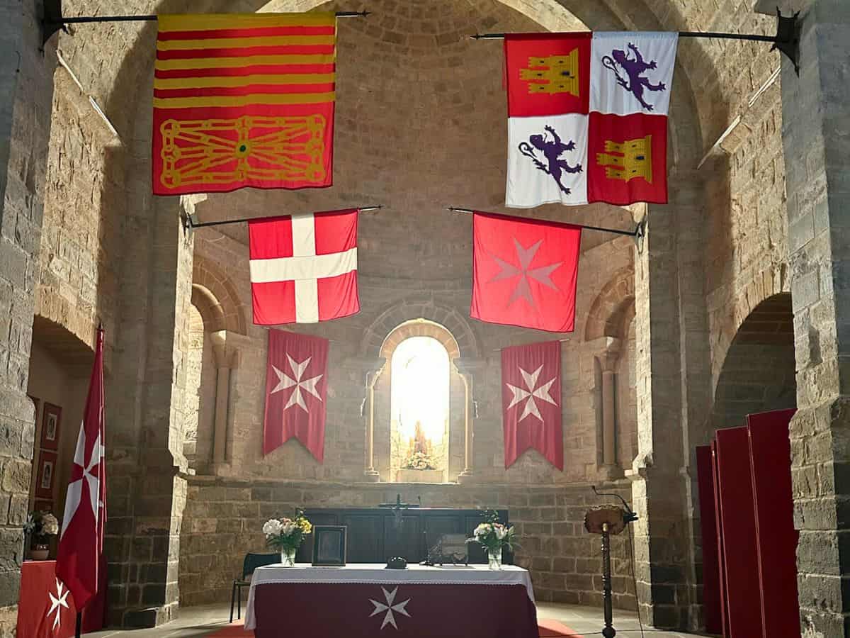 Iglesia Sanjuanista in Cizur Menor, showing flags honoring the Order of Malta. Religious tradition is one of the top reasons to walk the Camino.