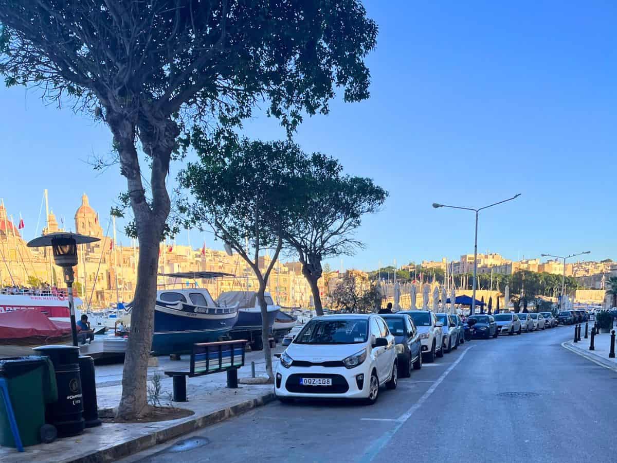 Cars lining the street along the marina in Senglea, Malta